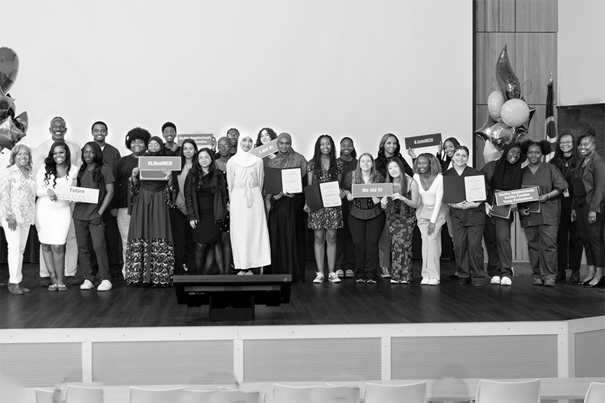 Large group of happy high school students standing on a stage