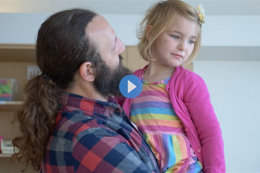 Bowel management patient at Nationwide Children's Hospital being held by her dad at the hospital