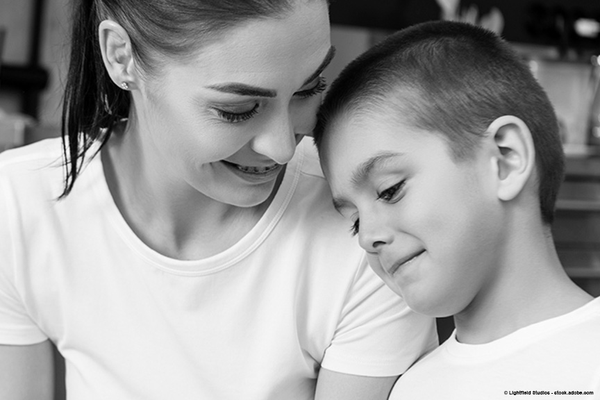 mother looking down at her son who seems to be experiencing some physical discomfort
