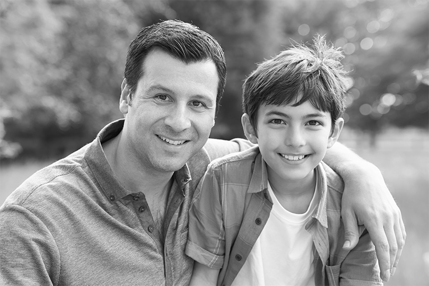 father and son smiling together outside