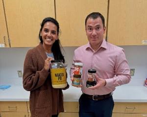 a man and a women holding canned goods