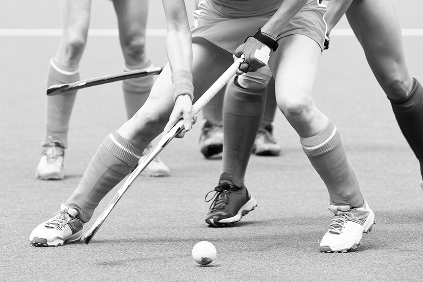Field hockey players with a field hockey ball and hockey sticks