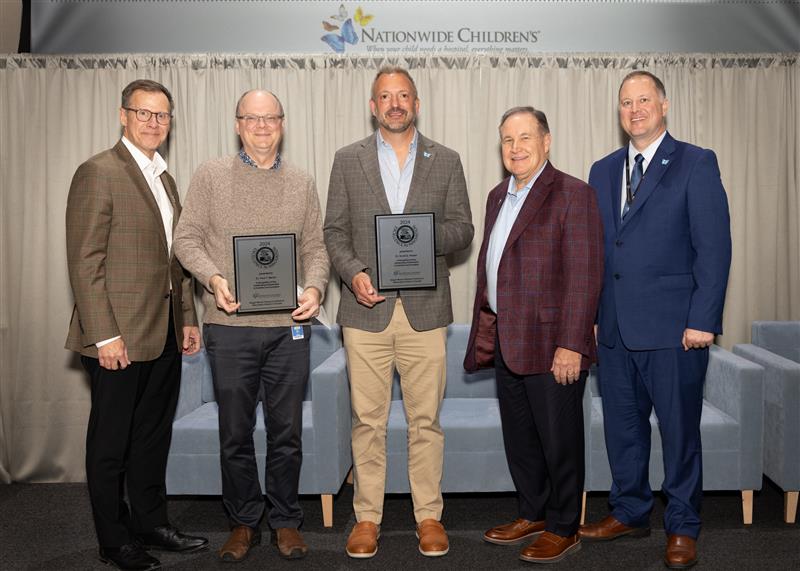 Researchers at Nationwide Children's Hospital holding innovator of the year awards alongside CEO Tim Robinson.