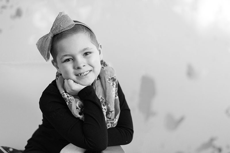 Young girl that's being treated at Nationwide Children's Hospital smiling for a photo.