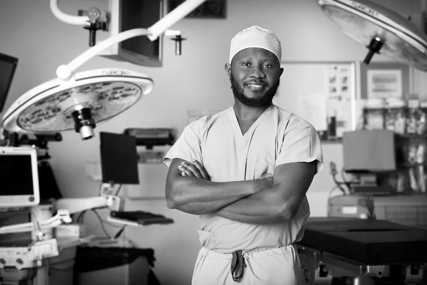 Albert Isaacs, MD, PhD, posing for a photo in an exam room with his arms crossed.